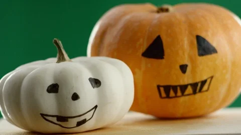 Video shows two painted pumpkins, green background, the focus is adjusted Stock Footage 111530568