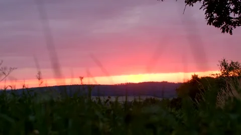 This video shows a vibrant sunset over a serene landscape Stock Footage 314346262