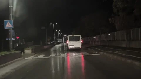 This video shows a white van driving on a wet road at night, with a following Stock Footage 292688092