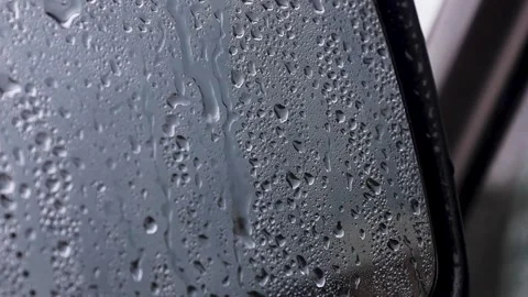 Video of a side mirror of a car with rain droplets. Stock Footage 344035151