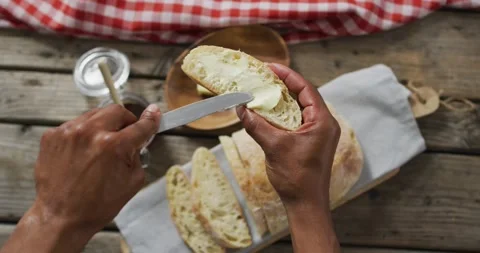 Video of slice of bread in hands on wooden worktop seeing from above Stock Footage 335452715