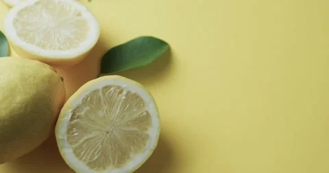 Video of sliced lemons with copy space over yellow background Stock Footage 331247946