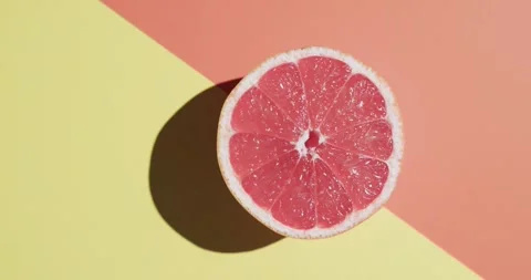 Video of sliced red grapefruit with copy space over orange and yellow background Stock Footage 331307246