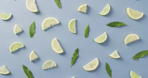 Video of slices of lemon and mint leaves lying on blue background Stock Footage 340881005