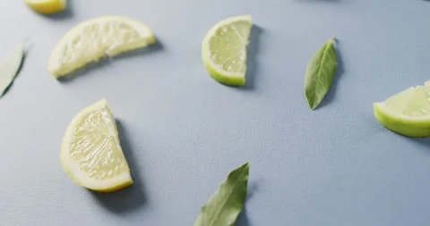 Video of slices of lemon and mint leaves lying on blue background Stock Footage 341664350
