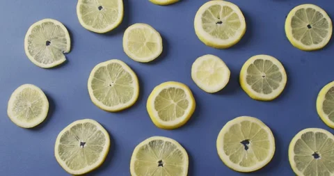 Video of slices of lemon lying on blue background Stock Footage 340985990