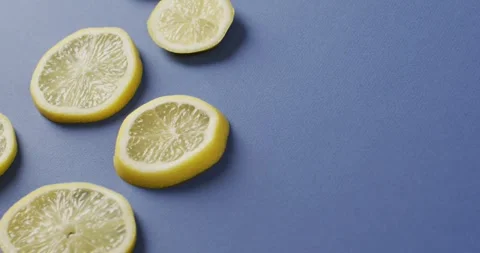 Video of slices of lemon lying on blue background with copy space Stock Footage 341851275