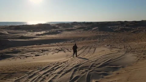 Video slow motion the guy walks along the dunes to the sea the sun Stock Footage 220624076