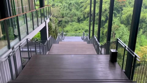 Video slow motion walking down wooden stairs towards green forest scenery Stock Footage 325973907