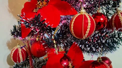 Video of a small Christmas tree decorated with red decorations. 4K Stock Footage 296574141