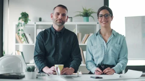 Video of smart architects working with plans while looking at camera in the o Stock Footage 171980377