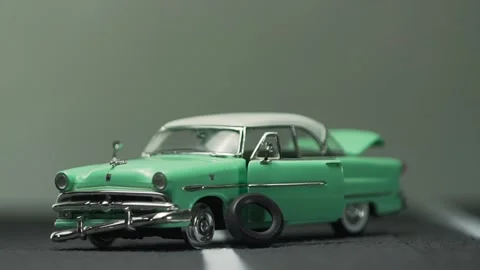 Video of a smashed, destroyed, light blue, retro car figurine left in the mid Stock Footage 133492414