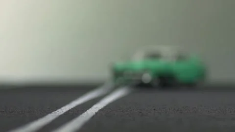 Video of a smashed, light blue, retro car figurine left in the middle of a hi Stock Footage 133491356