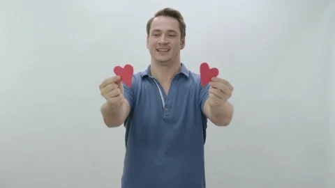 Video of a smiling man holding two paper hearts. Stock Footage 196477745