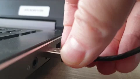 A video of someone putting a USB cable into a usb port of a laptop. Stock Footage 138260857