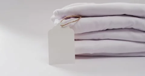 Video of stack of folded white t shirts with copy space on white background Stock Footage 331211074