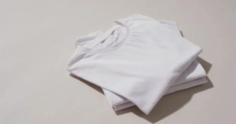 Video of stack of folded white t shirts with copy space on white background Stock Footage 331295189