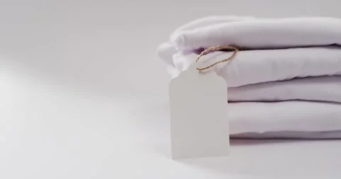 Video of stack of folded white t shirts with copy space on white background Stock Footage 331447697
