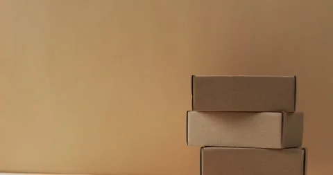 Video of stacked cardboard boxes with copy space over brown background Stock Footage 250508659