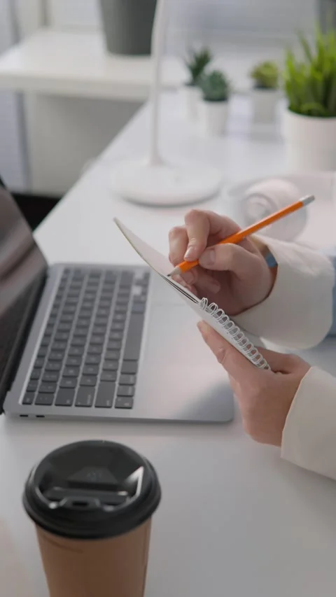 In this video, a student writes a report on her laptop on her home desktop. She Stock Footage 265979693