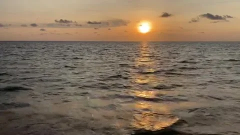 The video of a sunset on the right of the frame with vanilla sky and ocean beach Stock Footage 196979117