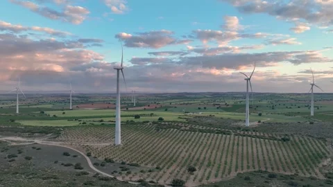 Video surrounding group of wind turbines in full operation with cloudy sky Video stock 274528023