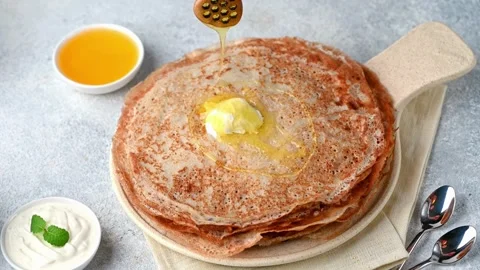 Video of Syrup being poured on to stack of tasty pancakes with melted butter. Vídeo Stock 336589051