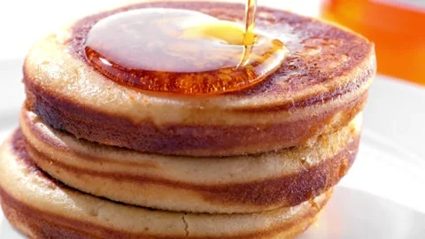Video of Syrup being poured on to stack of tasty pancakes with melted butter. Stock-Footage 336589104