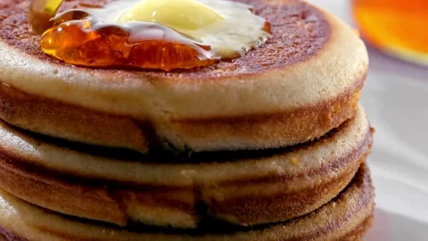 Video of Syrup being poured on to stack of tasty pancakes with melted butter. Stock-Footage 336589108
