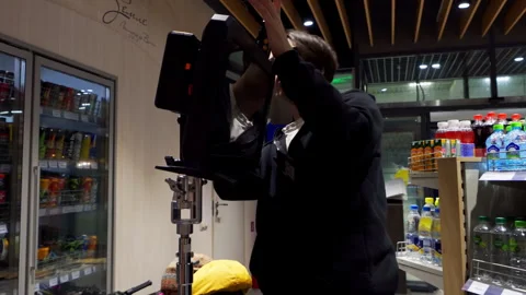 Video technician carefully adjusts camera monitor on tripod Stock Footage 303063570