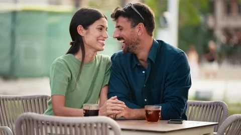 Video of tender couple talking and laughing while having a drink on a terra.. Video stock 332846942