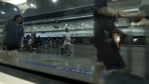 Video through train window of people walking by looking for their train,4k Video stock 281855009