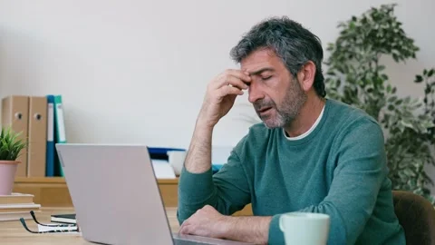 Video of tired man with headache working with laptop at the office Stock Footage 340829022