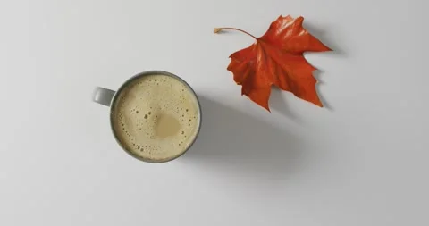 Video of top view of mug with coffee and fall leaf on white background Stock Footage 337399391