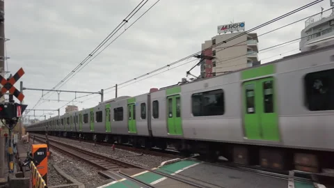 Video tracking a train of Yamanote passing over the level crossing of Komagome. Stock-Footage 166734740
