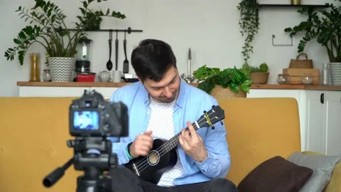 Video tutorial, online music training. Blogger records video  playing guitar. Video stock 153042676
