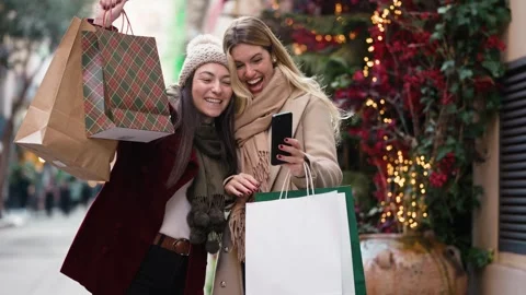 Video of two beautiful friends doing videocall with smartphone while walkin.. Stock Footage 340825276