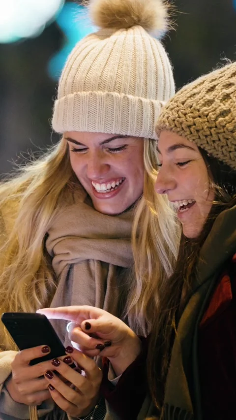 Video of two beautiful friends using smartphone while walking on the city s.. Stock Footage 340825882