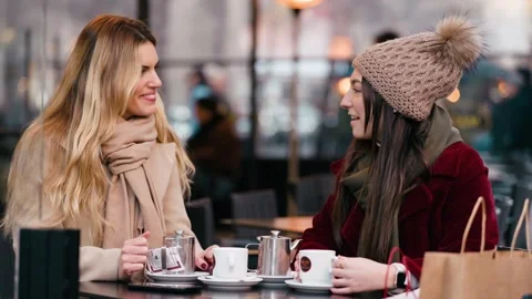 Video of two beautiful women talking while drinking coffee sitting in the b.. Stock Footage 340825317