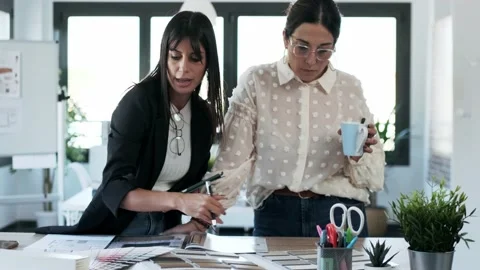 Video of two beautiful young designer women working in a design project while Stock Footage 154829027