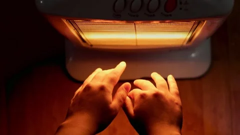 Video of two female hands reaching out to an electric heater seen from above. Stock-Footage 245877389