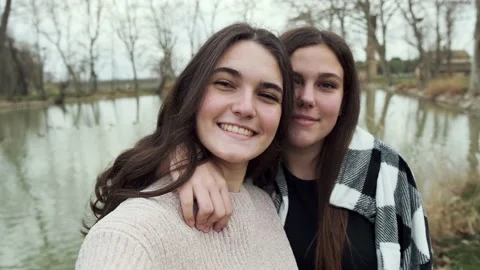 Video of two girls using their smartphones while taking selfies in the middle Video stock 162818204