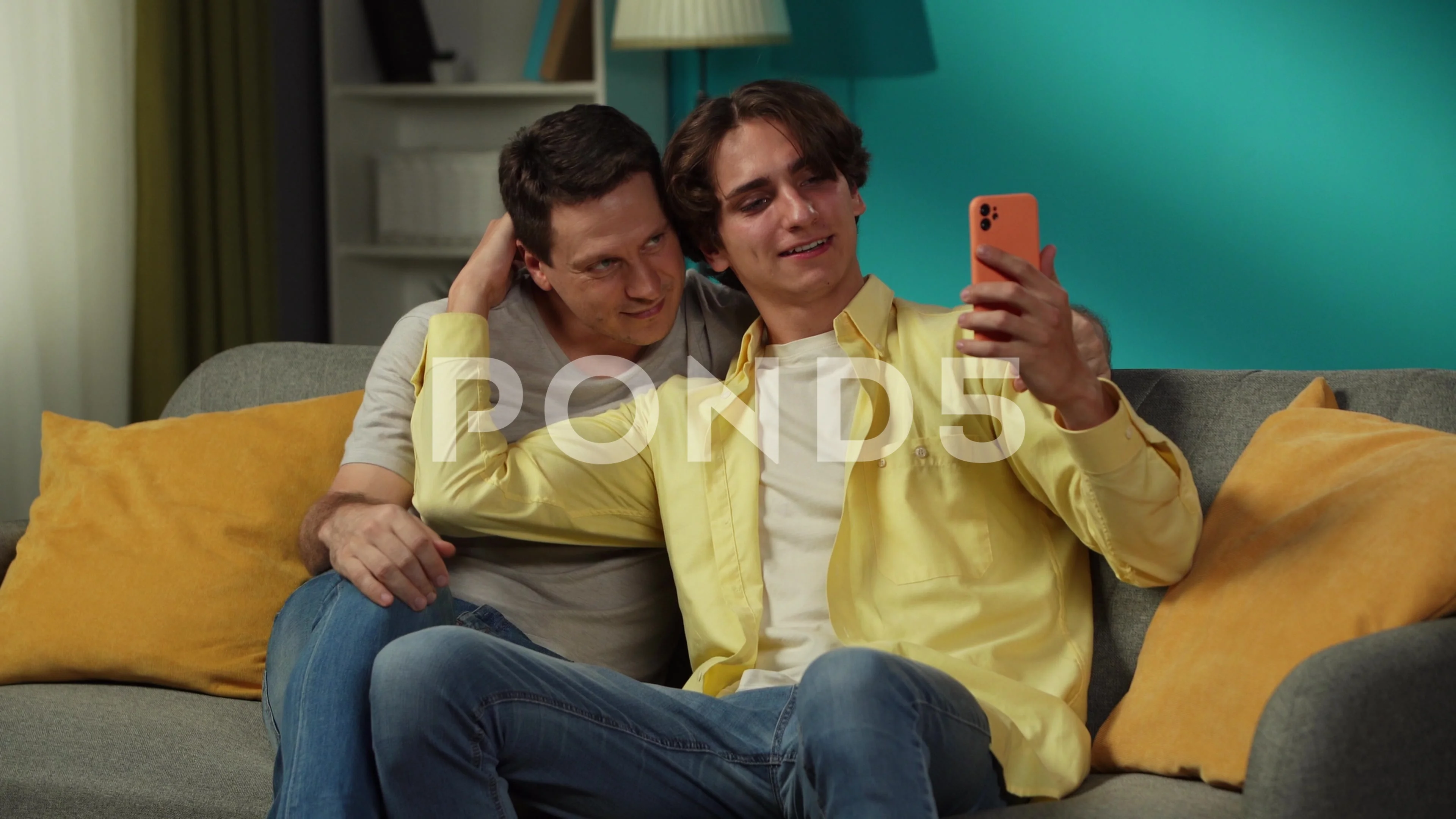 Video of two homosexual men, couple at home. They are sitting on the couch