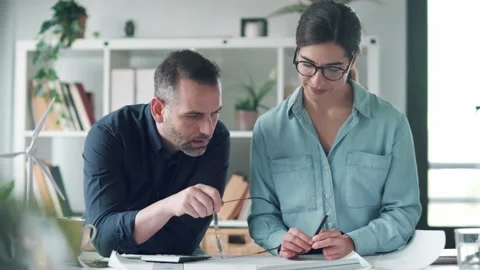 Video of two smart architects design over blueprint while taking notes in the Video stock 171980442