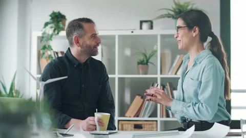 Video of two smart architects having a break while talking and drinking coffe Stock Footage 171980427