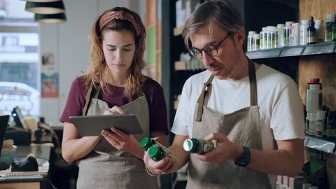 Video of two store owners using digital tablet to doing inventory together of Stock Footage 201823539