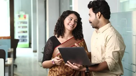 Video of Two young happy colleagues using laptop and communicating together Stock Footage 244124756