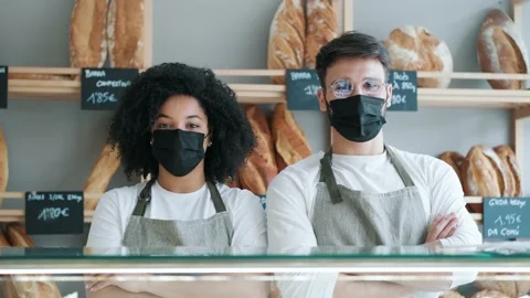 Video of two younger owners with protective medical mask selling fresh pastry Stock Footage 193410369