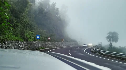 A video of vehicles moving on a hilly road in India during a foggy day. Stock Footage 159792191