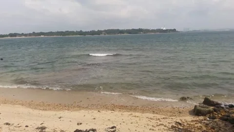 Video of a view of the beach with a small island in the middle during the day Stock Footage 324355731